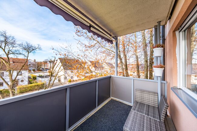 Überdachter West-Balkon mit schönem Blick ins Wohngebiet – ideal zum Entspannen.